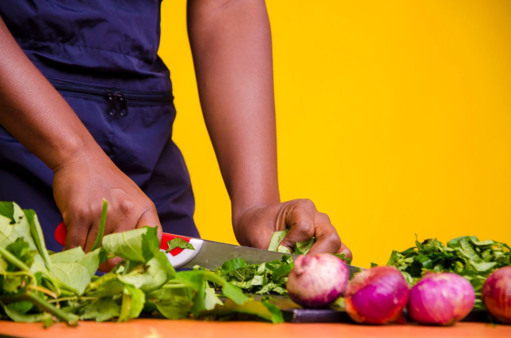 Close,Up,A,Nigerian,Housewife,Cutting,Vegetables,In,The,Kitchen Individual cutting groceries